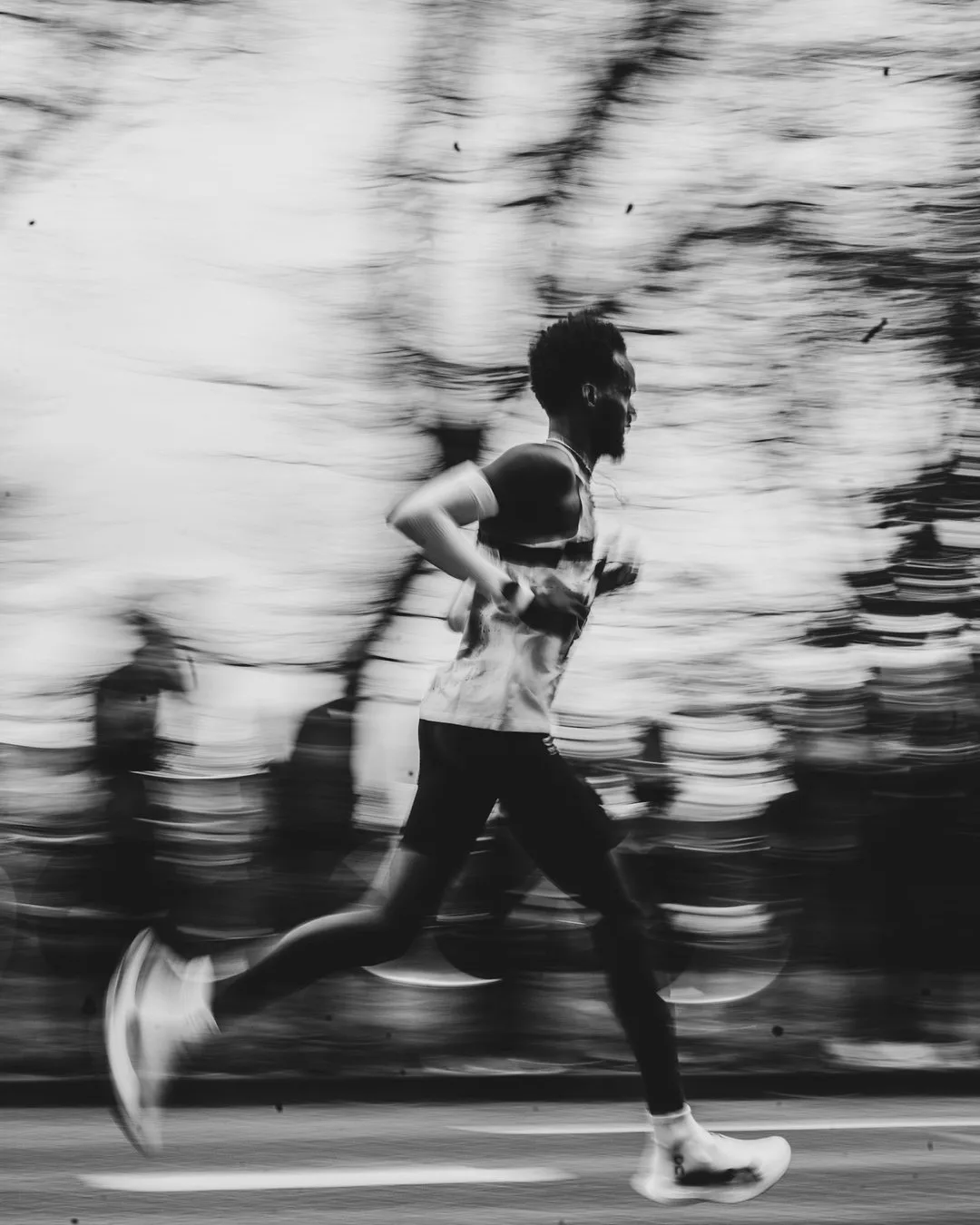 A runner mid-stride with a smartwatch on his wrist.